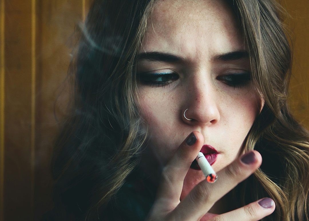 girl with nose ring smoking a cigarette